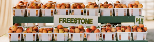 Baskets of peaches at a farmers market, waiting to be sold