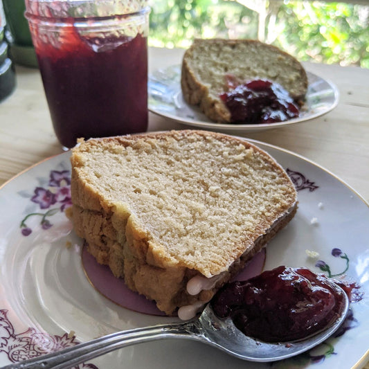 A slice of Sassyfras Strawberry bundt cake served with a teaspoon of strawberry jelly