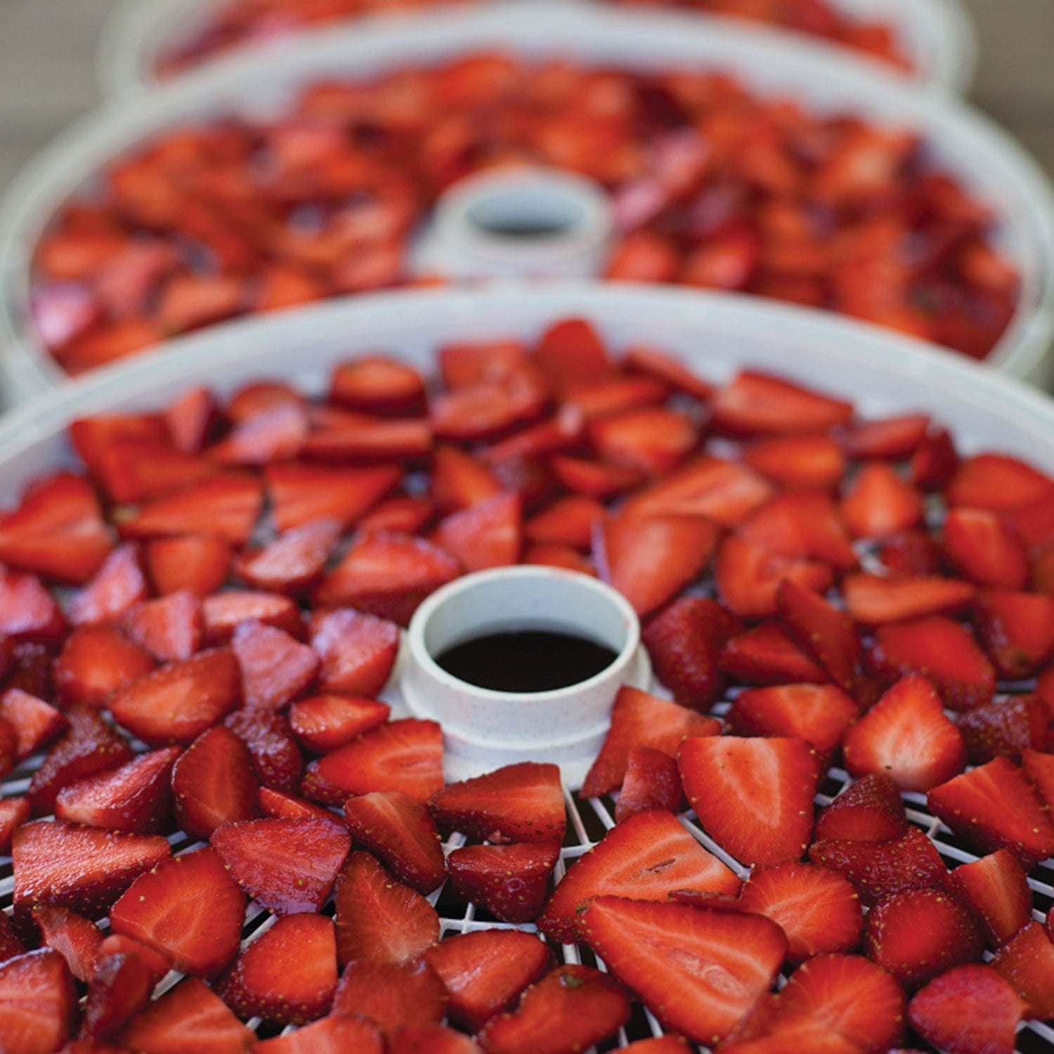 A tray of strawberries on a wooden table.