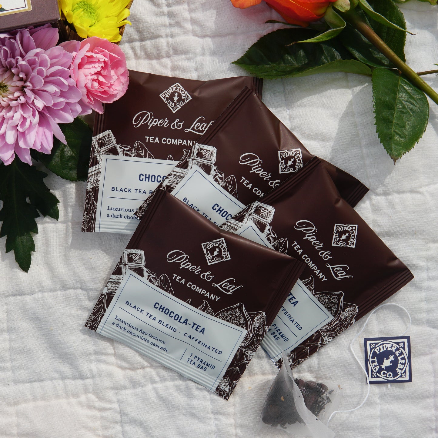 The Mother's Day Special Tea Sampler by Piper & Leaf Tea Co. features 16 individually wrapped tea bags, elegantly packaged—an ideal gift or sampler for Mother's Day, with floral accents and a brand sticker adding to its charm.
