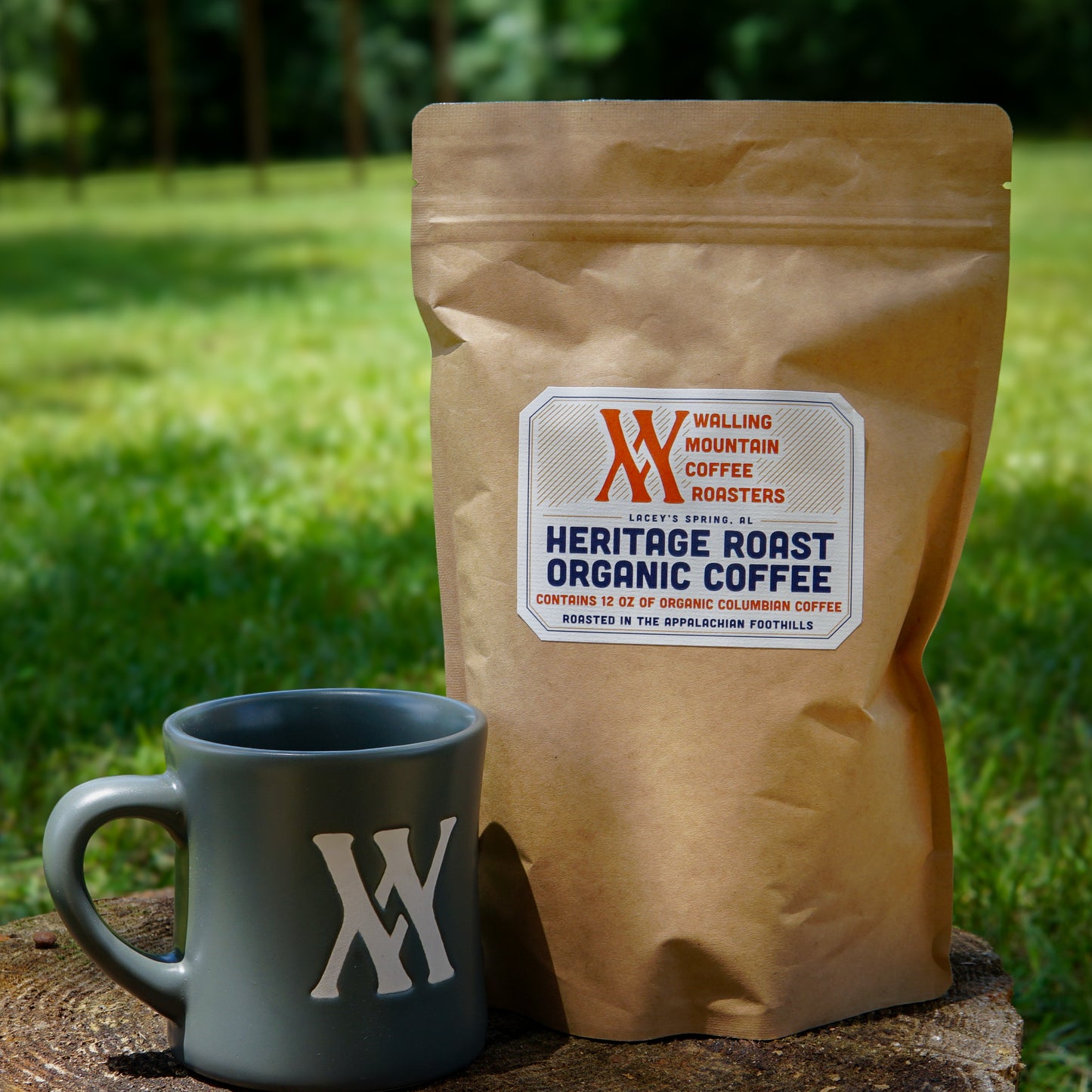 A Walling Mtn. Coffee + Mug Bundle sits on a wooden surface outdoors, featuring a coffee bag and matching gray mug with the Walling Mtn. Coffee logo, with grass and trees visible in the background.