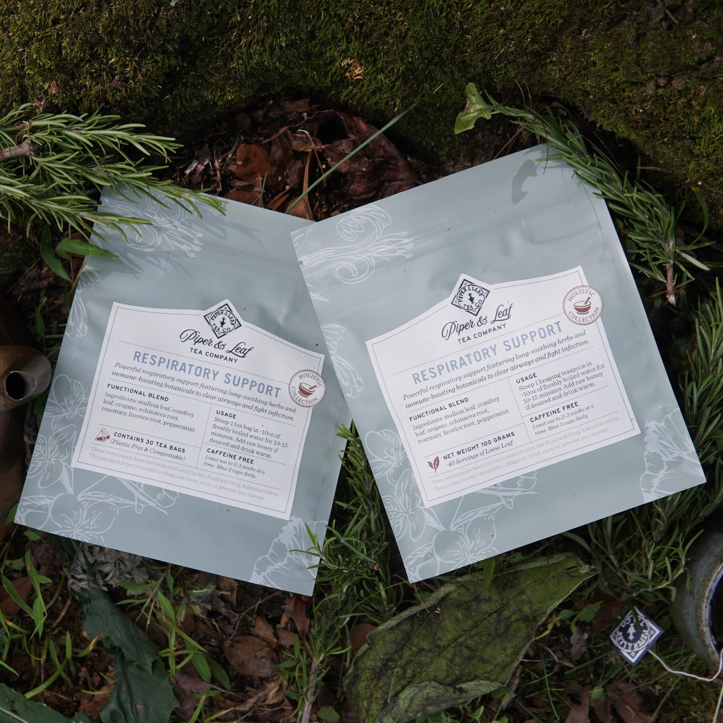 Two light blue resealable bags of Piper and Leaf Tea Co.’s “Respiratory Support” herbal tea blend are set among greenery, suggesting easy breathing and a healthy immune response with every soothing cup.