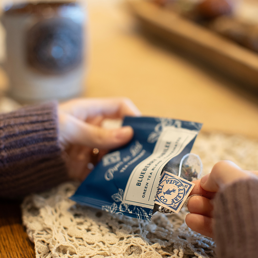 opening and pulling out a tea bag sachet