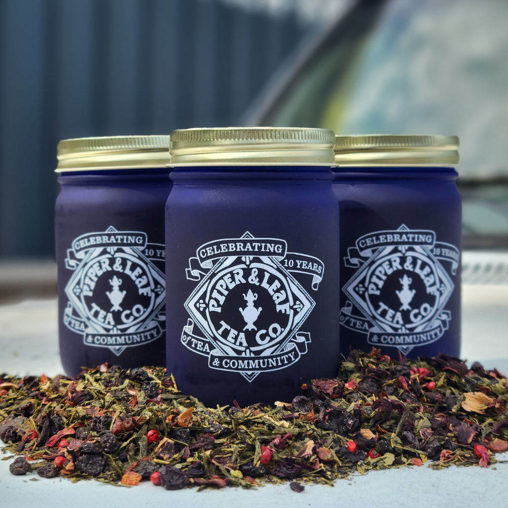 three blueberry jubilee loose leaf jars surrounded by loose tea
