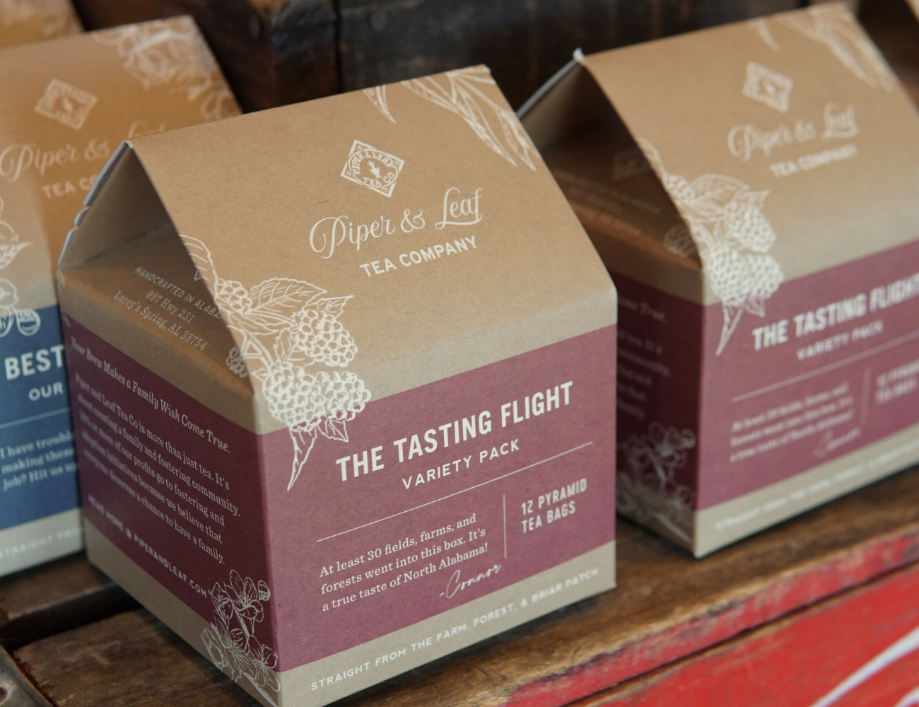 Boxes of "The Tea Tasting Flight- Box of 12 Individually Wrapped Tea Bags" blends variety pack by Piper & Leaf Tea Co. displayed on a wooden surface.