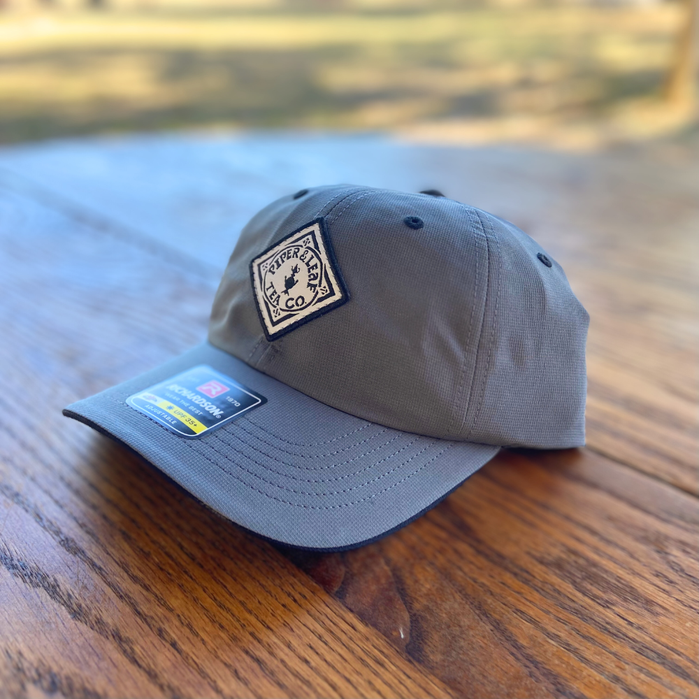 A P&L Sport Cap from Piper & Leaf Tea Co. on a table.