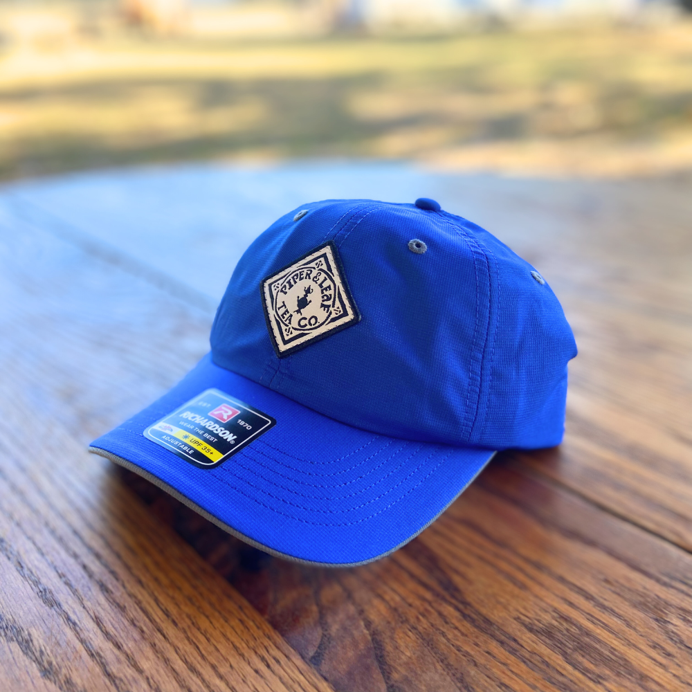 A blue Richardson cap with a Piper & Leaf Tea Co. logo on it.