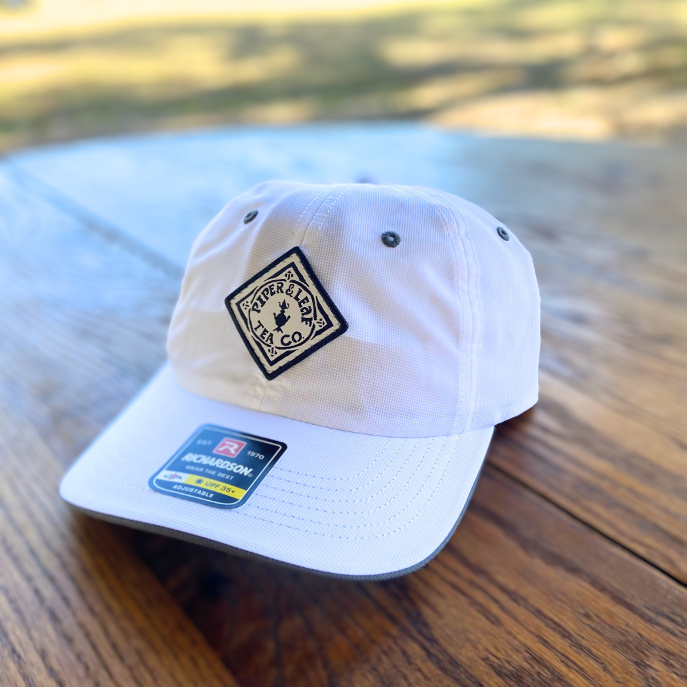 A Piper & Leaf Tea Co. P&L Sport Cap on a table.