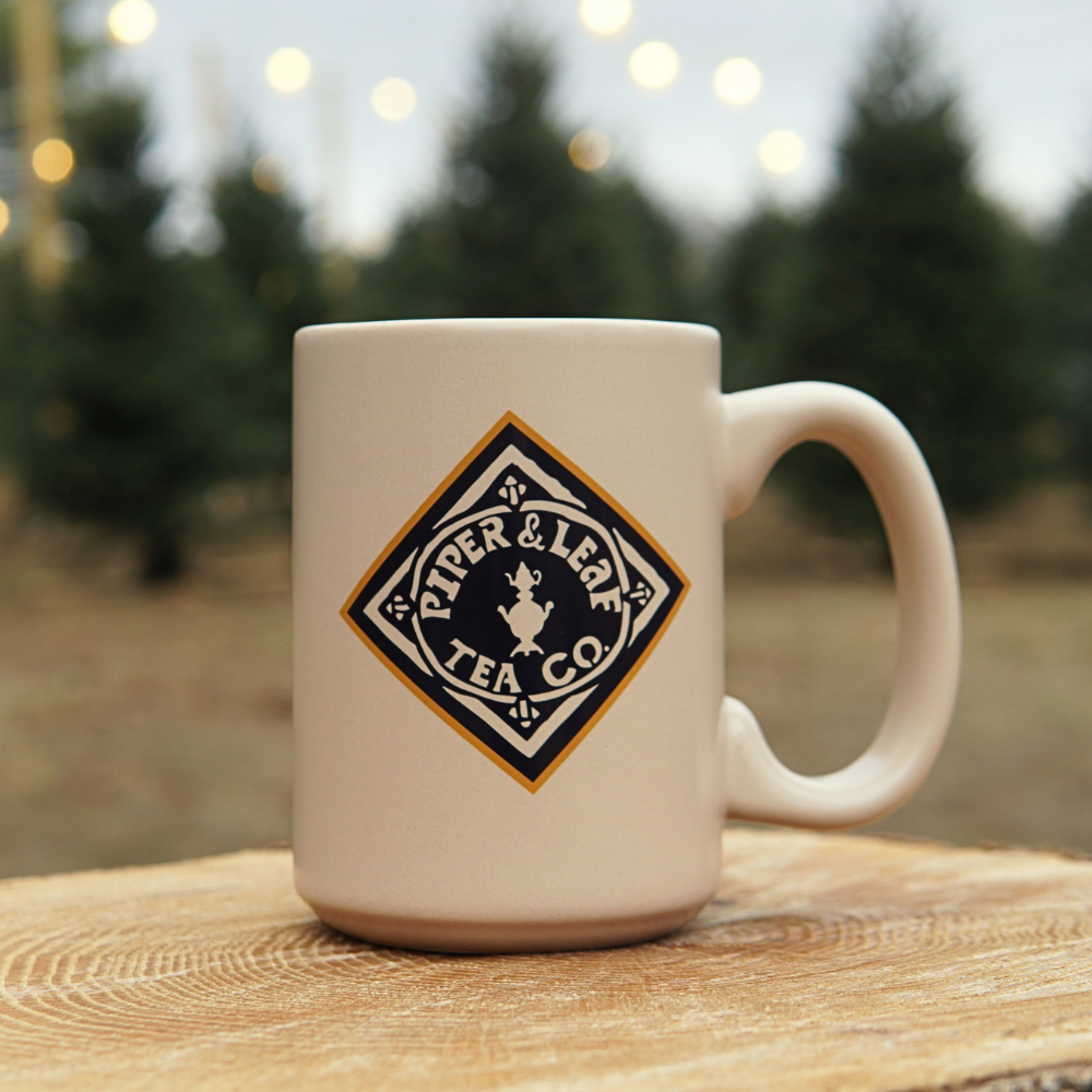 back side of the Piper & leaf goat mug featuring the P&L diamond logo in orange and navy blue