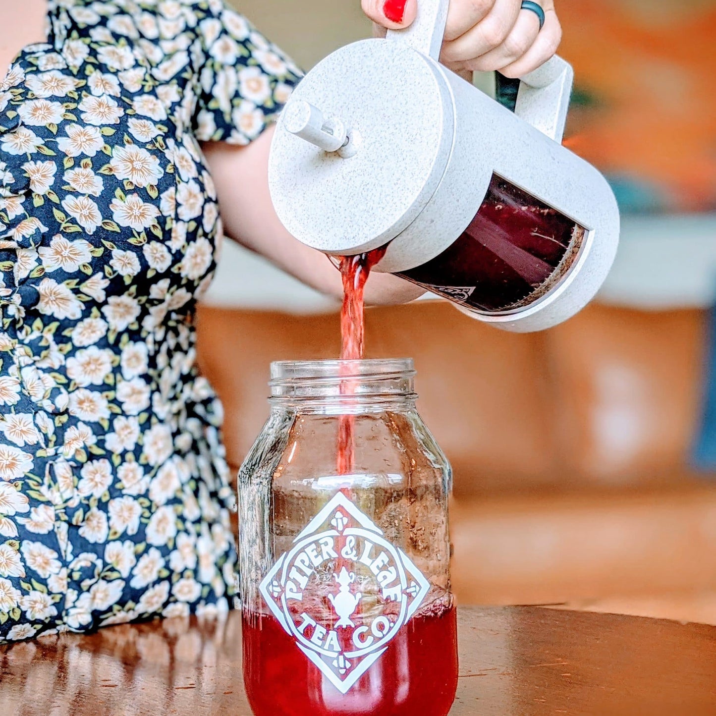 Pouring freshly brewed tea from a Piper Press into a Piper & Leaf quart jar