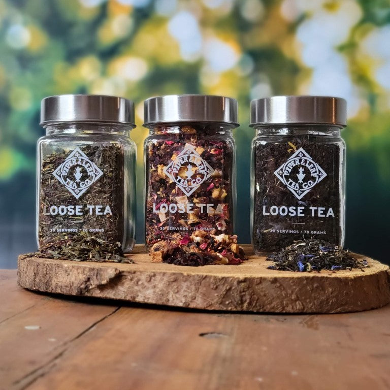 Three 3pk of Loose Leaf Jars of Piper & Leaf Tea Co. loose leaf tea, showcasing signature tea blends, placed on a wooden board.