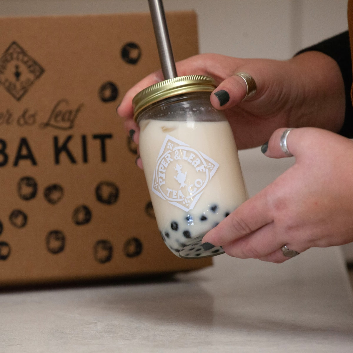 A close up of bubble tea in a pint mason jar