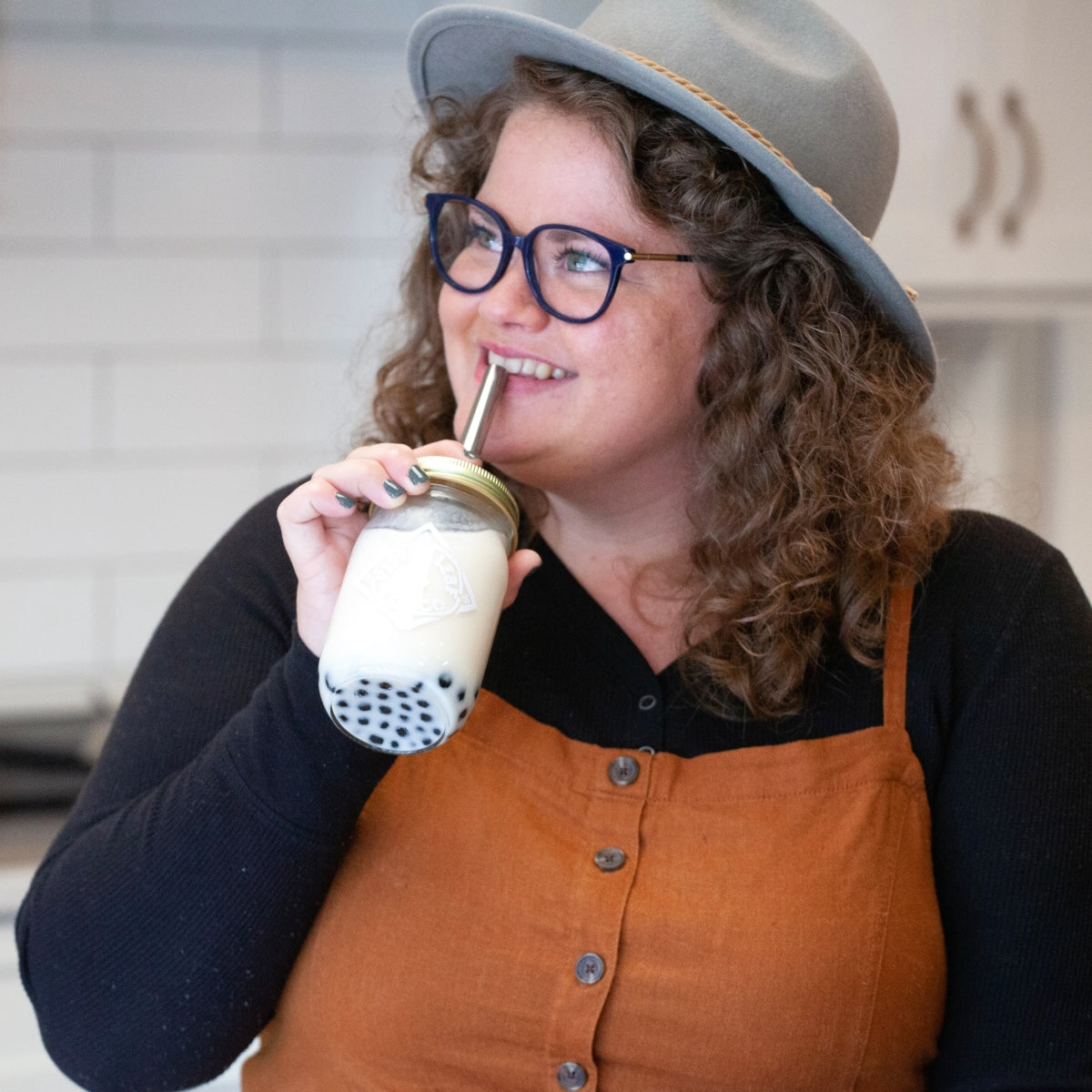 A girl sipping bubble tea out of a pint mason jar