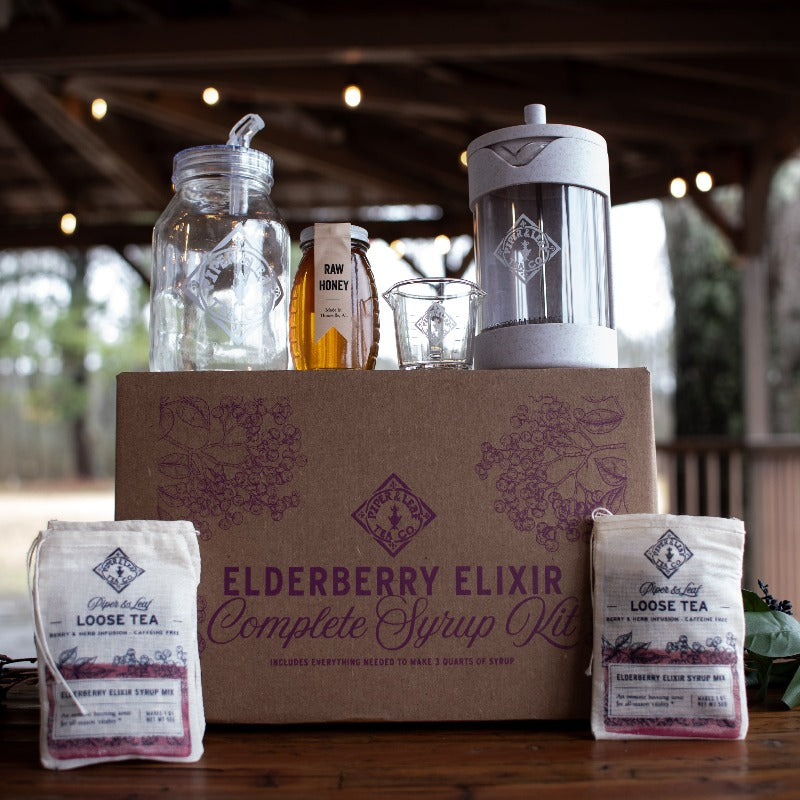 box including 3 muslin bags of Elderberry Elixir loose leaf tea, one Piper Press, 1 glass quart jar with P&L logo, one small glass measuring cup, and one jar of local raw honey