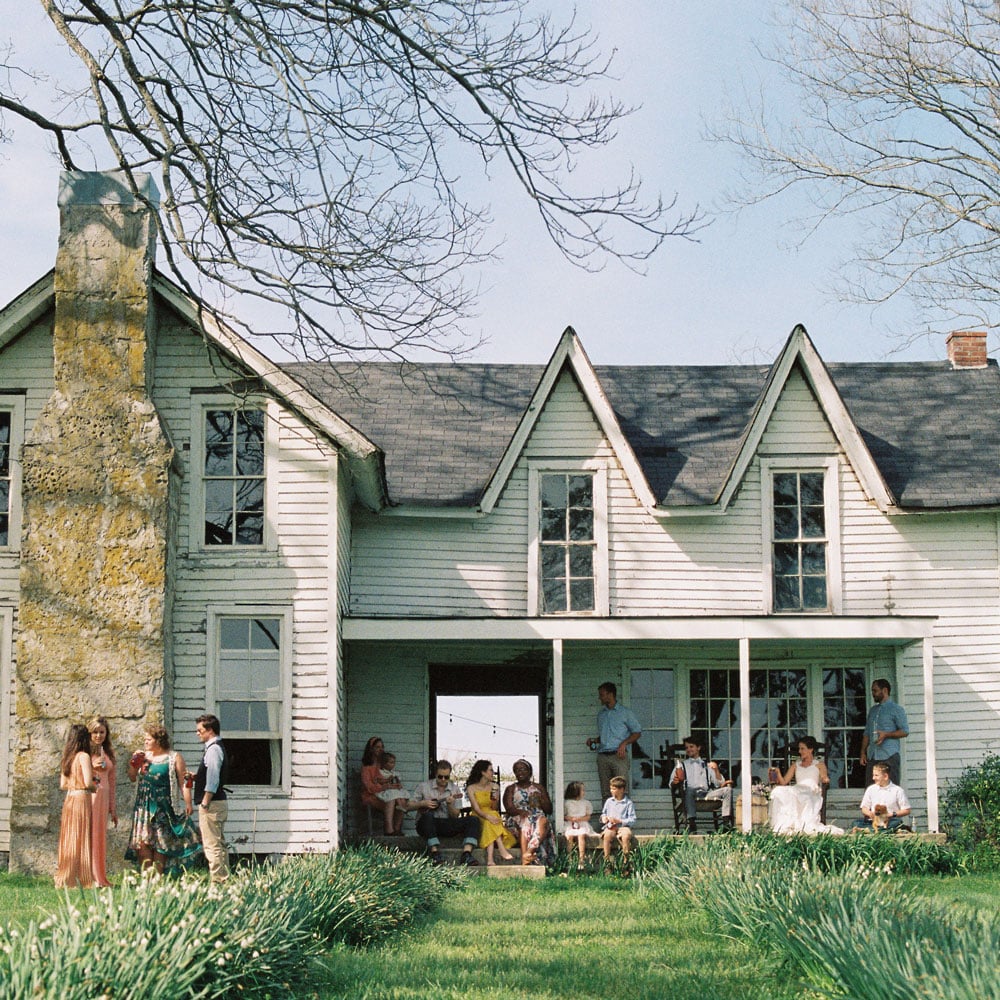 A large family mingles around the front porch enjoying company and jars of their favorite iced tea: Front Porch Special