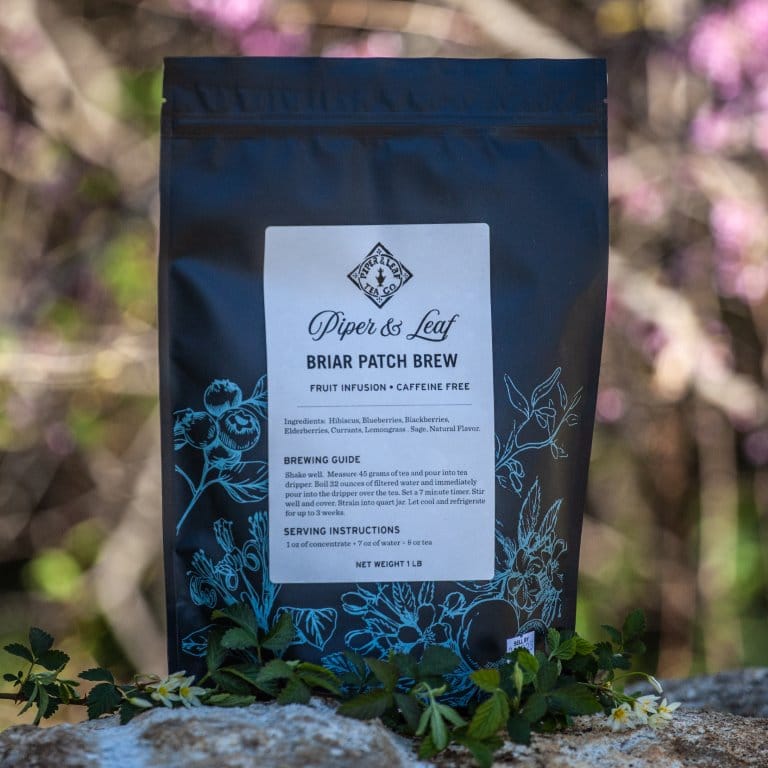 A Piper & Leaf Tea Co. Briar Patch Brew Pound Bag - 190 servings of loose leaf green tea sitting on a rock.