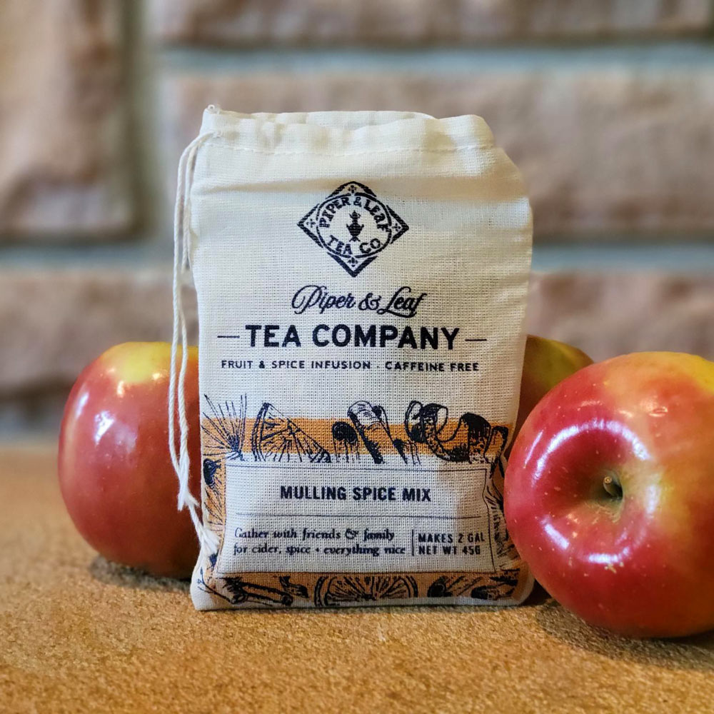 A muslin bag of Mulling Spice Mix surrounded by apples