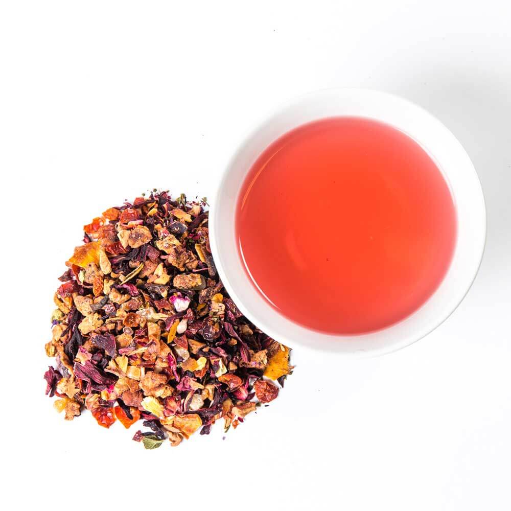 a pile of loose leaf next to a cup of brewed tea - Orchard Peach