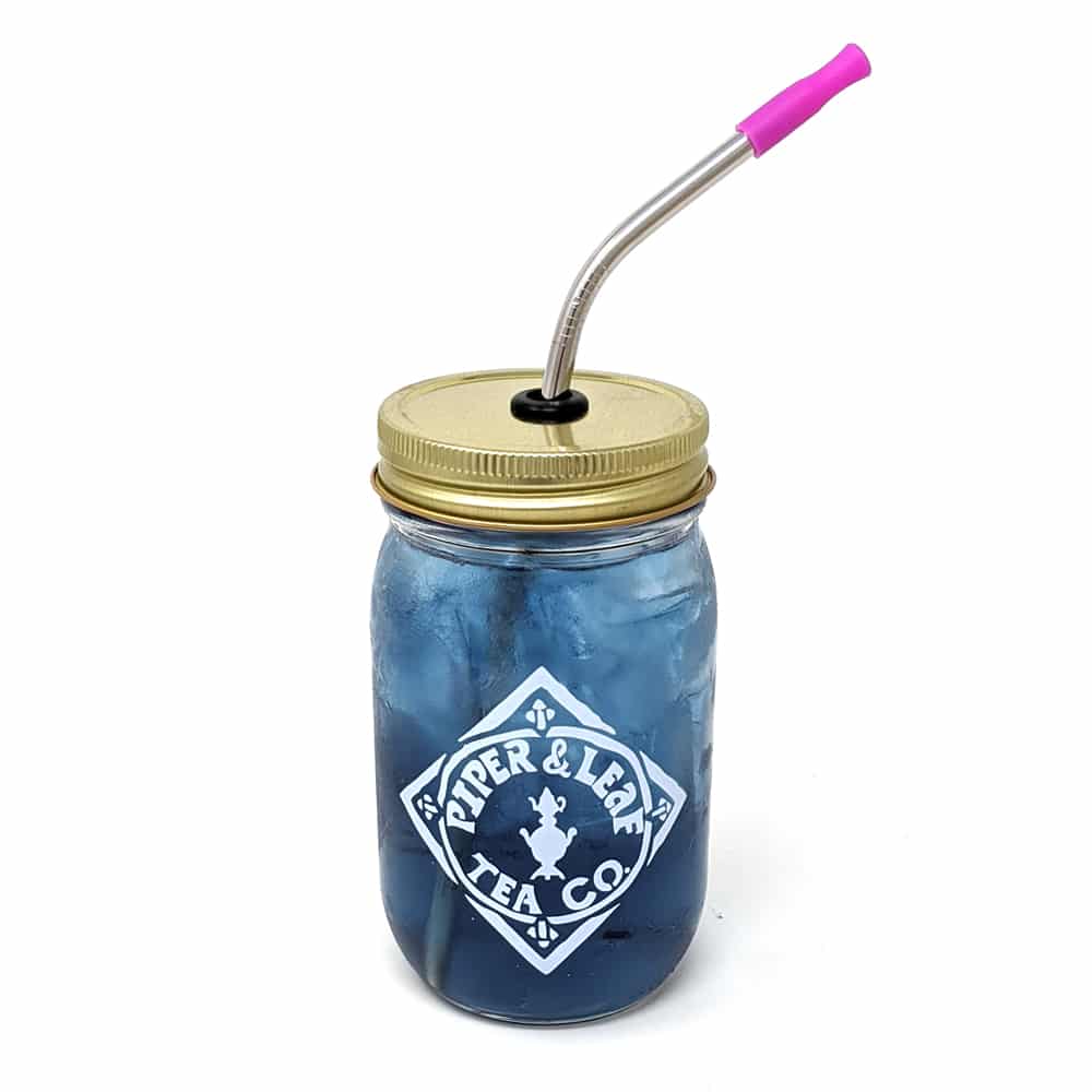 A Piper & Leaf pint jar with a white logo and a bent reusable metal straw