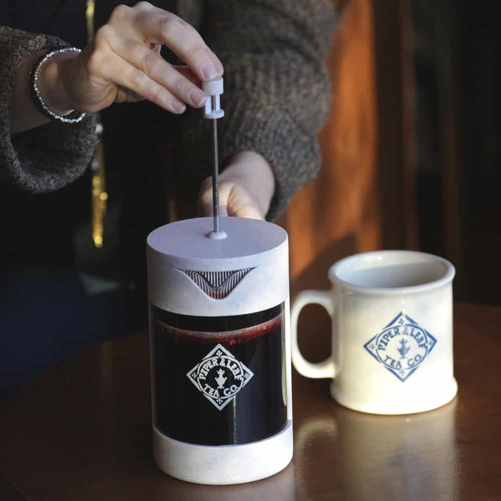 Pressing down the Piper Press to strain the brewed tea