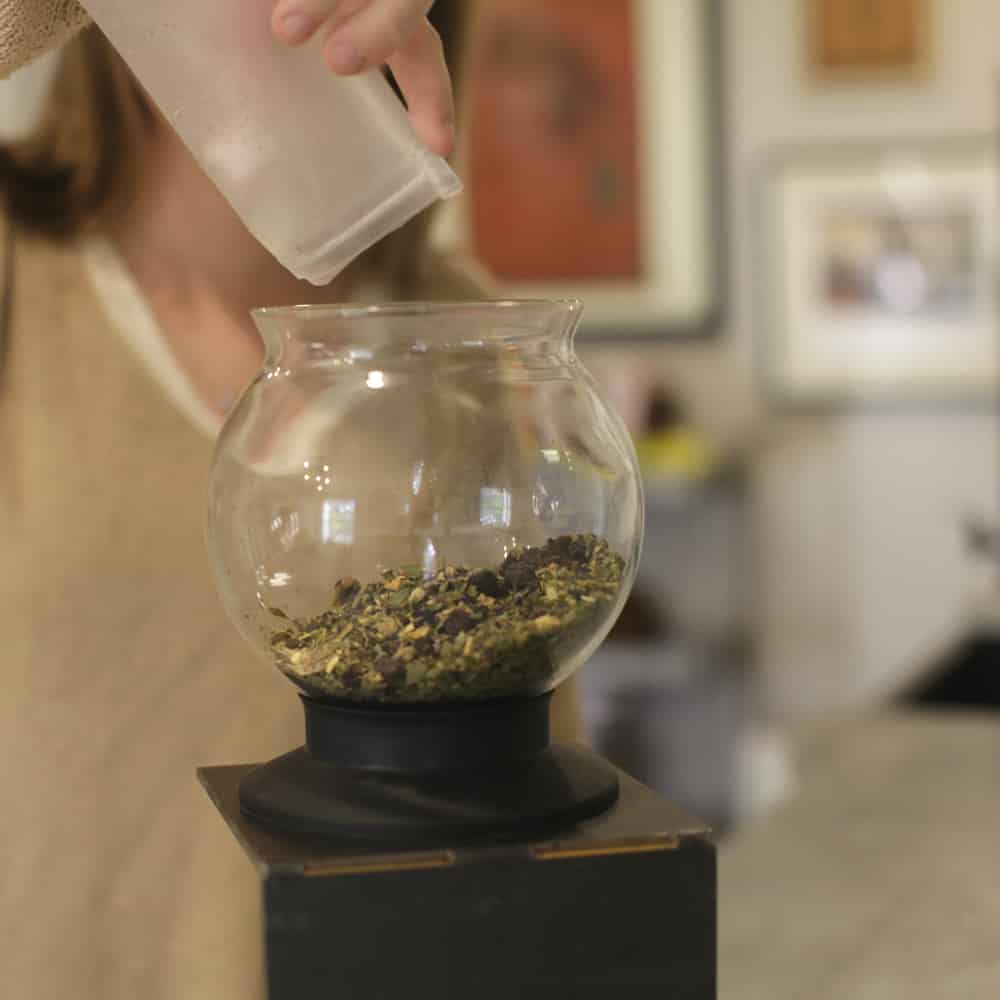 Pouring a full muslin bag of loose leaf into a Tea Dripper