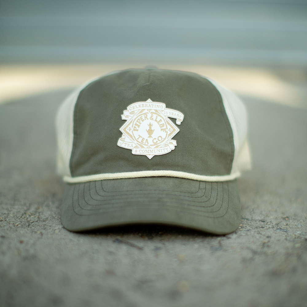 A P&L Anniversary Soft Trucker Hat with a white patch on it made by Piper & Leaf Tea Co.