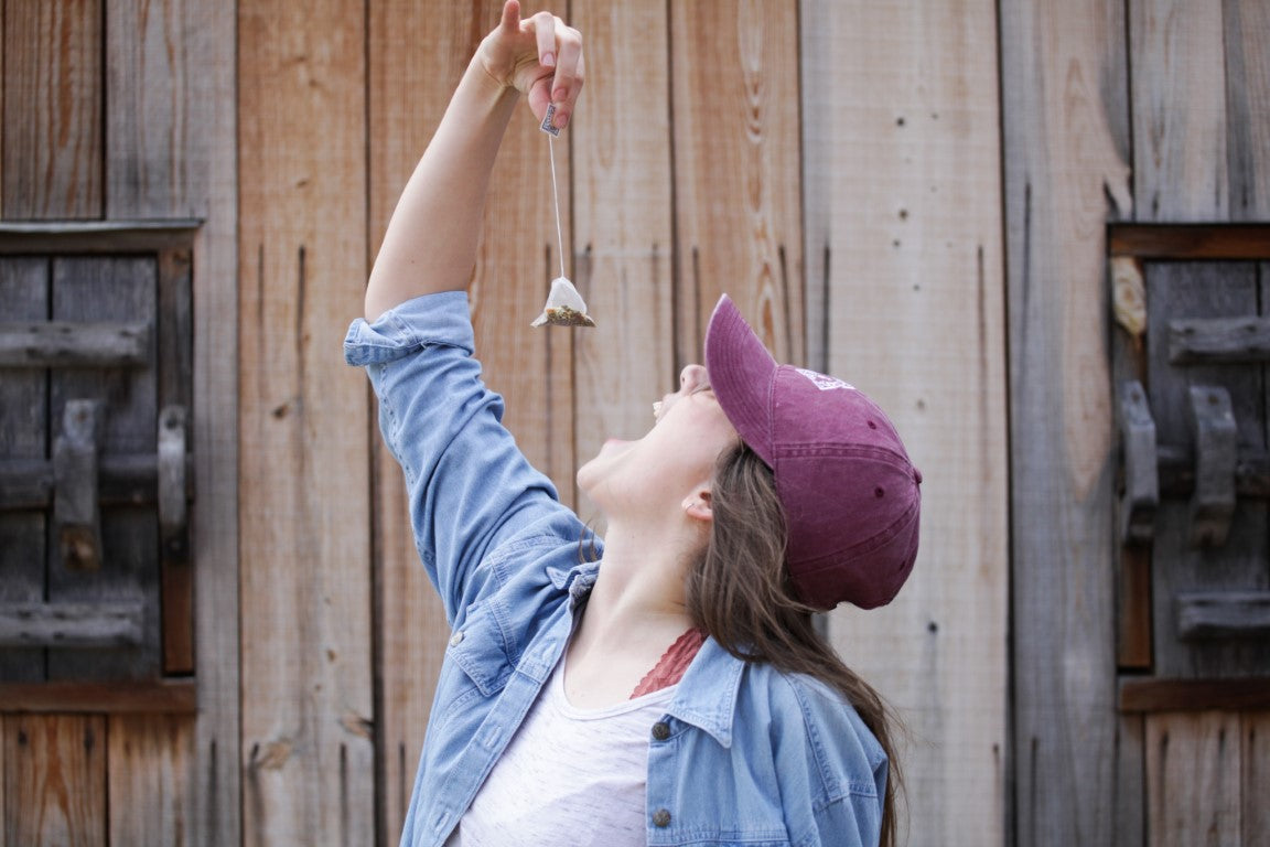 Girl holding a sachet tea bag 