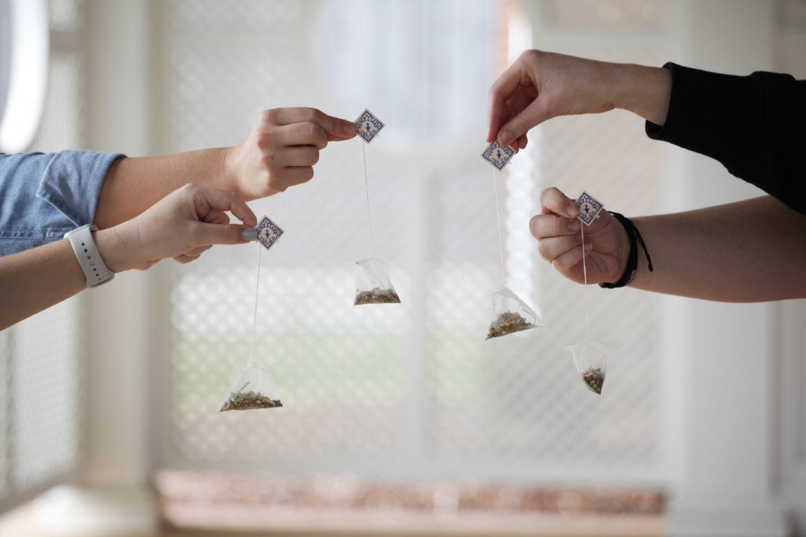 Girls holding 4 sachet tea bags