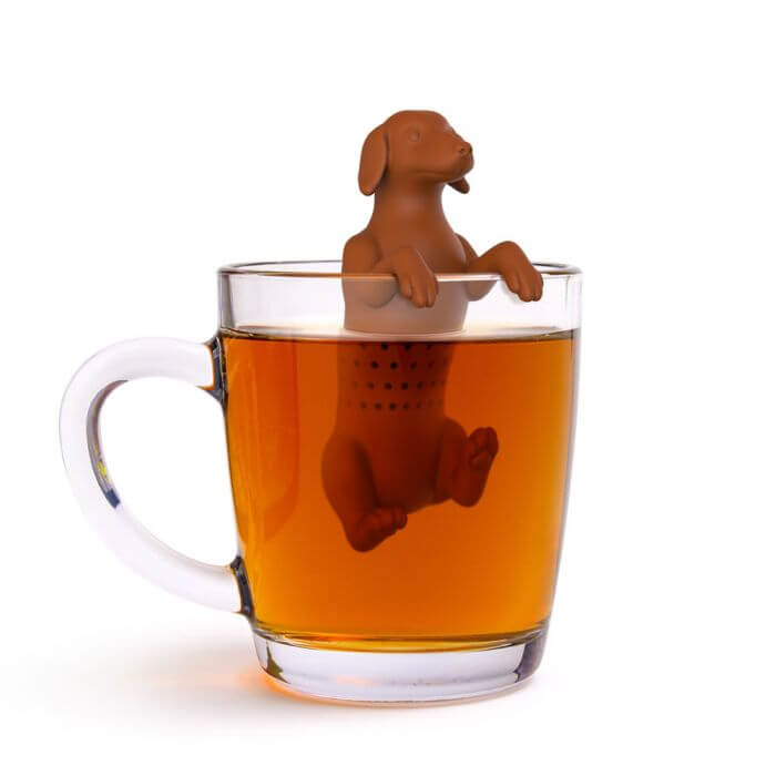 A dog shaped Fred-brand tea strainer in a glass mug: the Hot Dog