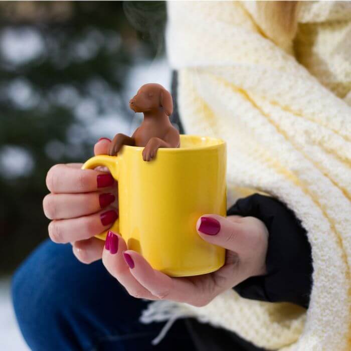 A dog shaped Fred-brand tea strainer in a yellow mug: the Hot Dog