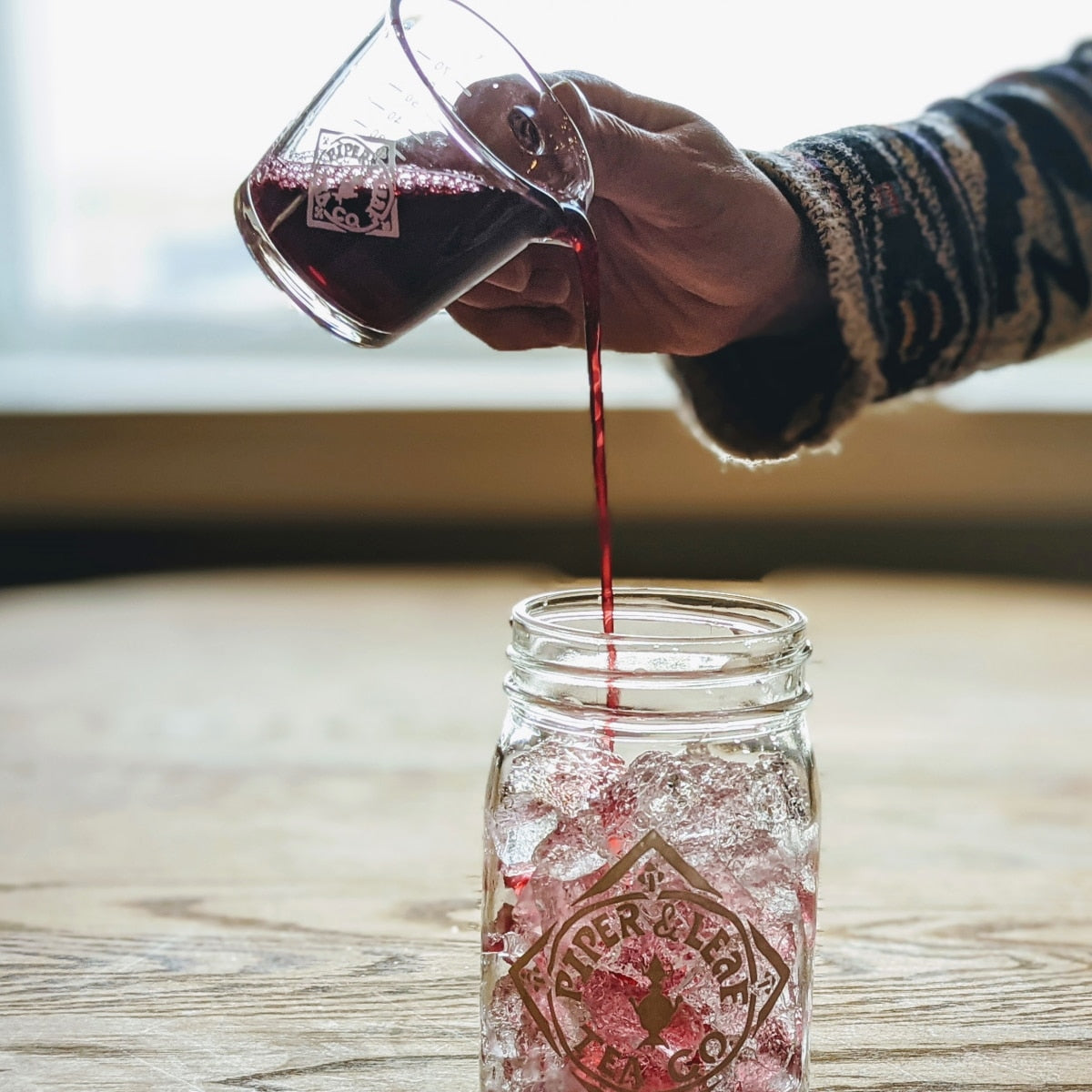 Piper Mini Measure - a tiny measuring cup pouring concentrated tea into a pint jar of ice