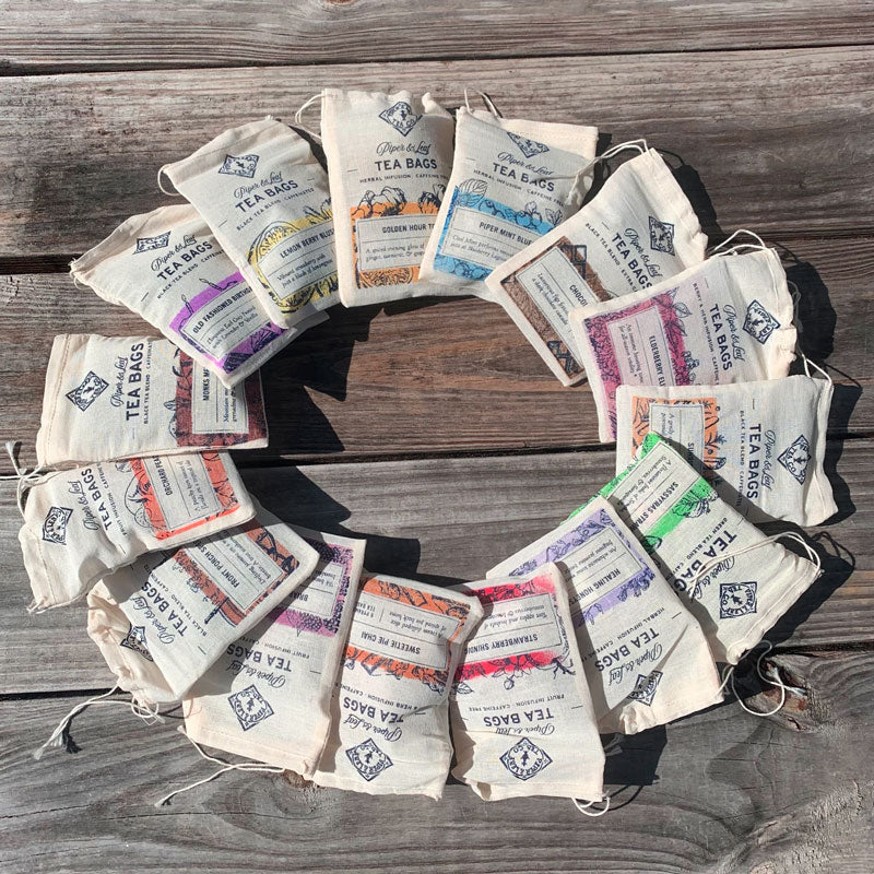 A circle of 15 Piper & Leaf blends in colorful muslins of tea bags