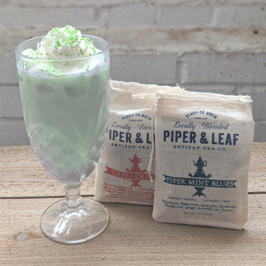 A green milk tea with whipped cream and sprinkles - made with Piper Mint Blues (herbal mint) and Capri Cream (milk oolong)