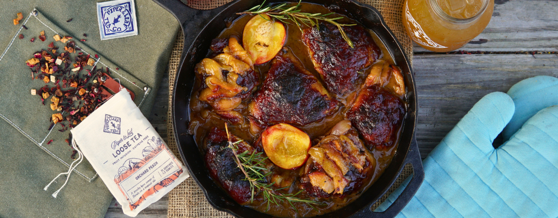 Crisp and Juicy BBQ chicken thighs with caramelized onions and fresh peaches, sitting in a skillet atop a rustic picnic table, beside a glass of iced cold peach tea and loose leaf peach tea