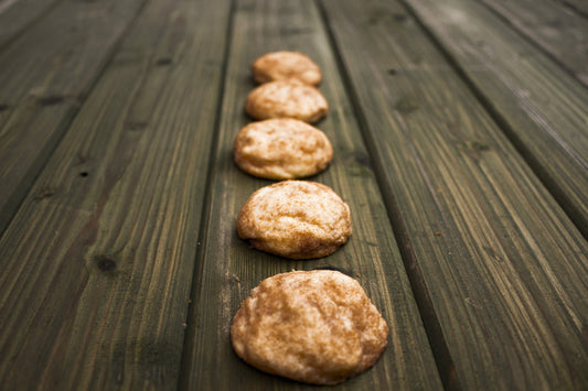 Snickerdoodle cookies lined up on a wood table