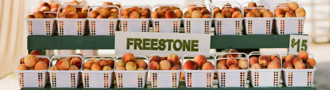 Baskets of peaches at a farmers market, waiting to be sold 