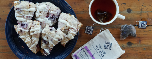 Fresh, warm Old Fashioned Birthday Cake scones sitting on a plate next to a cup of hot tea, waiting to be savored and eaten