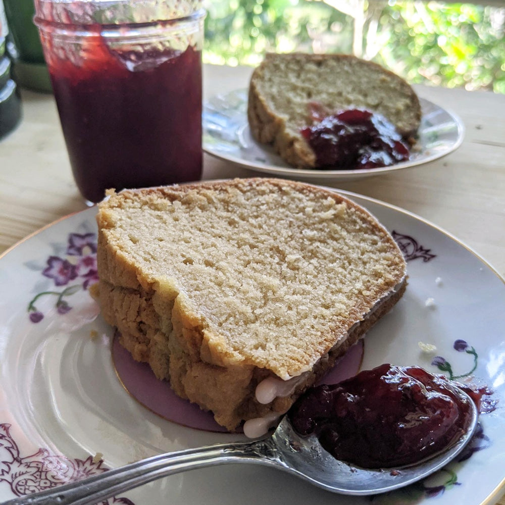 A slice of Sassyfras Strawberry bundt cake served with a teaspoon of strawberry jelly