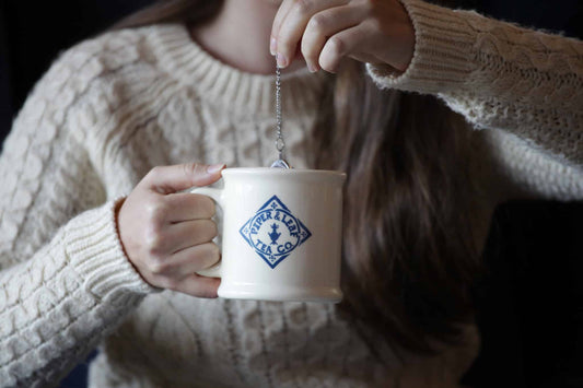Steeping loose leaf tea in a Piper & Leaf logo mug with a tea ball strainer