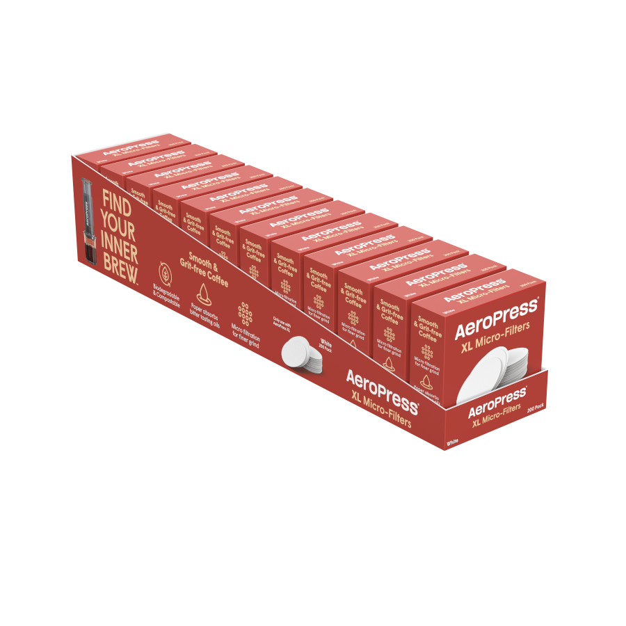 A long red AeroPress box labeled "AeroPress Paper Micro-Filters - XL" holds stacks of round white filters in compartments, with the text “Find Your Inner Brew” printed on the box.