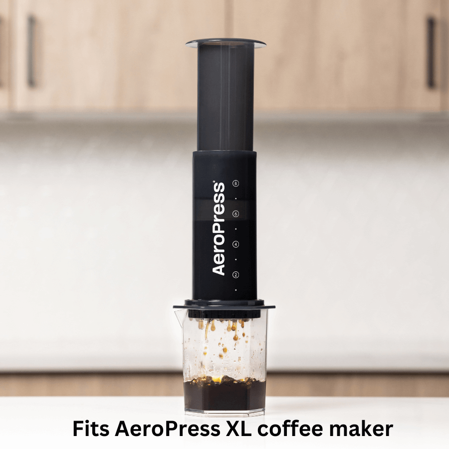 AeroPress Paper Micro-Filters - XL by AeroPress sit on a kitchen counter with an AeroPress XL coffee maker, ensuring smooth, grit-free brews when used with the AeroPress XL and compatible filters.