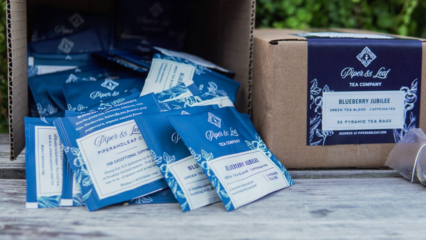 A Blueberry Jubilee Case of Individually Wrapped Tea Bags- 50ct by Piper & Leaf Tea Co. sitting on a wooden table in a pantry.