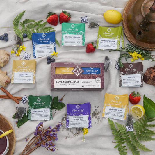 Piper & Leaf Tea Co. Caffeinated Sampler - Box of 16 Tea Bags, including green and other caffeinated blends, displayed with fruits, herbs, and flowers.