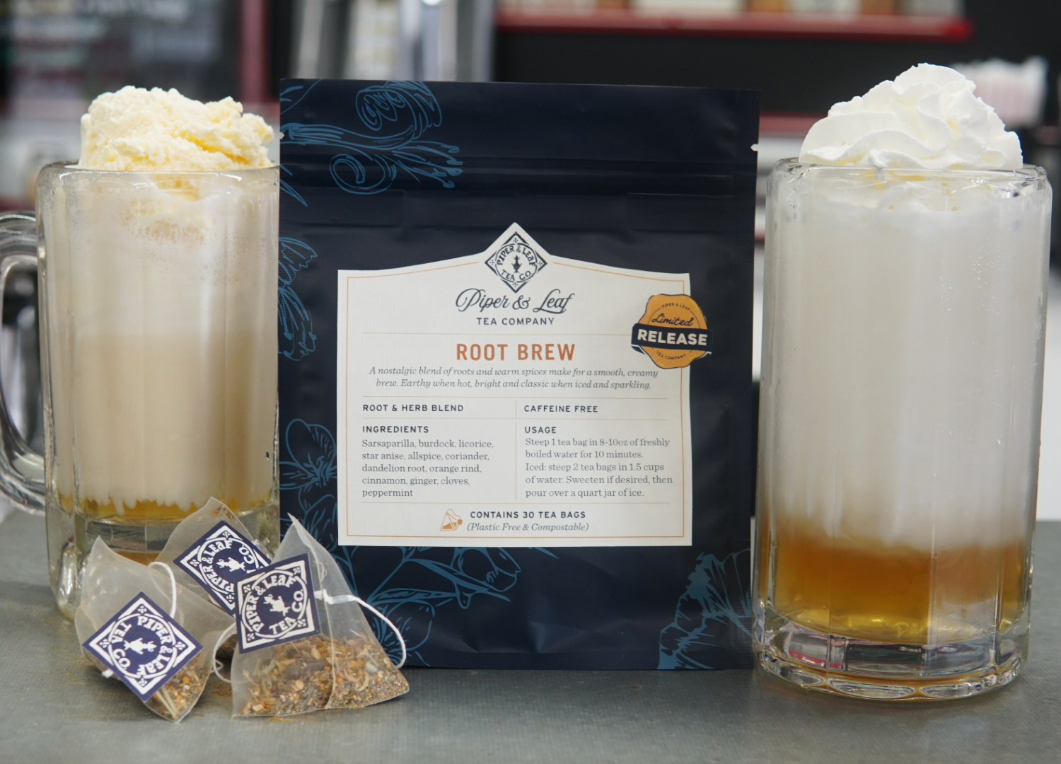 Two root beer floats with whipped cream sit beside a bag of Piper and Leaf Tea Co.'s Root Brew and three wrapped tea bags, ready to deliver the nostalgic, creamy flavor of this unique blend to your counter.