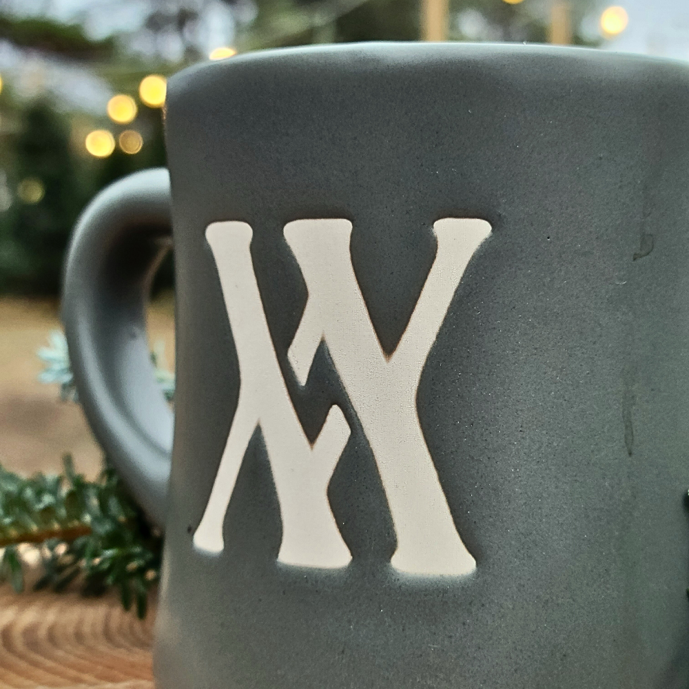 upclose look Walling mtn. coffee mug in sage green with an etched in cream logo