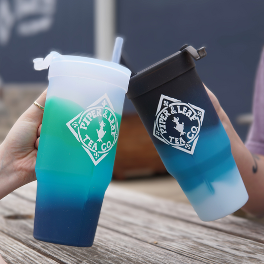 Two people holding Piper & Leaf Tea Co. branded Limited Edition- P&L X Silipint 32oz Tumblers with Handle, savoring their limited edition iced tea.