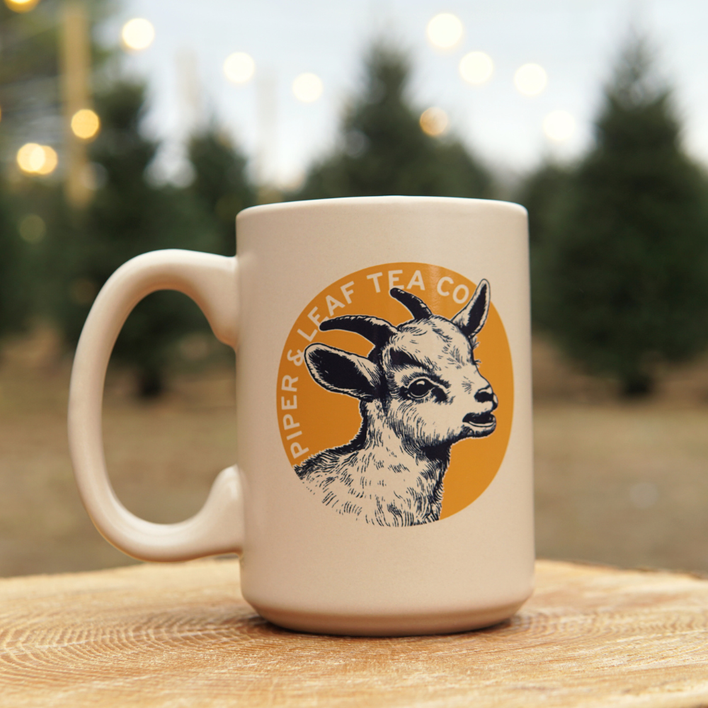 Piper & Leaf Goat mug, cream base with orange and blue accents