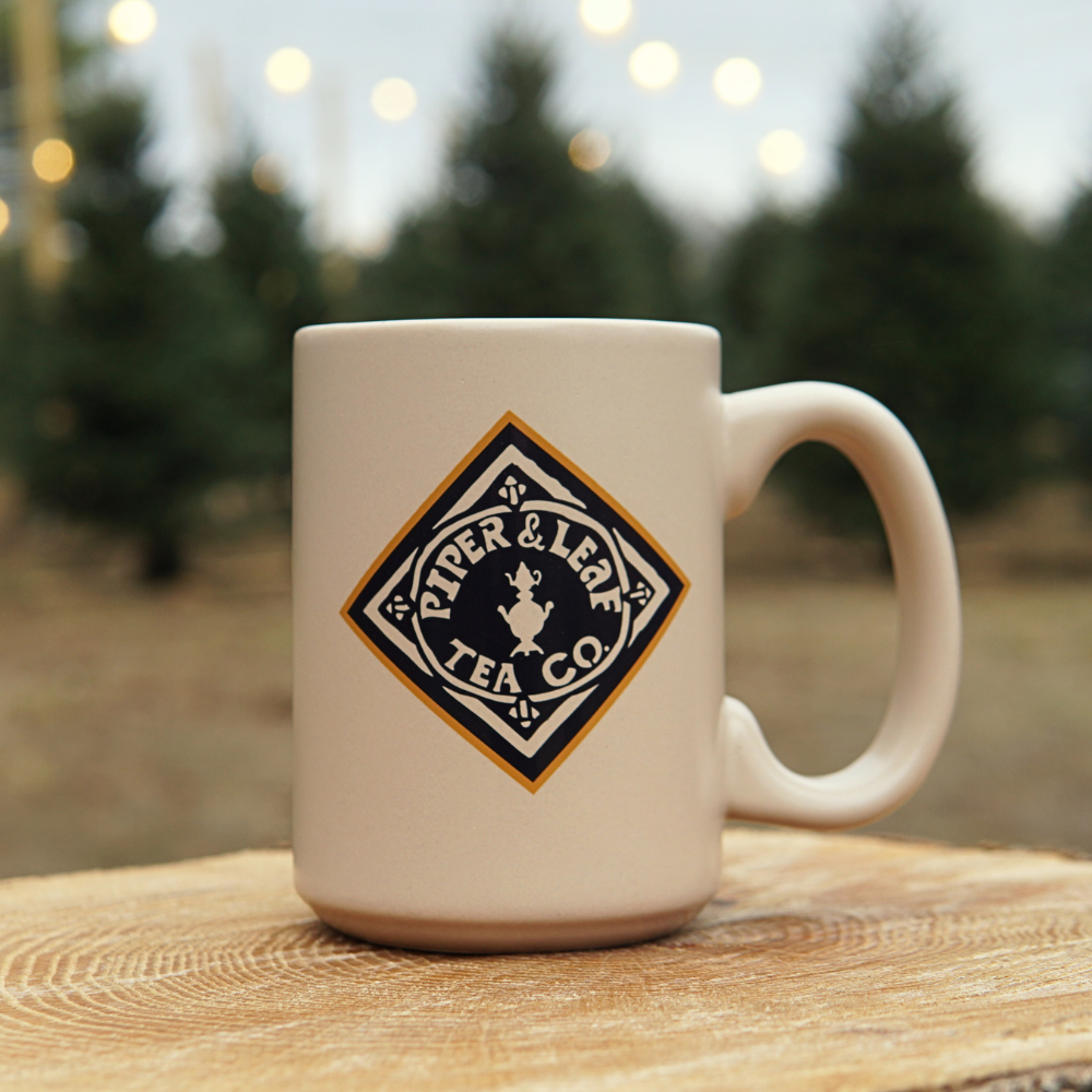 back side of the Piper & leaf goat mug featuring the P&L diamond logo in orange and navy blue 