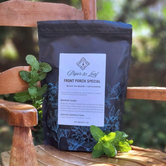 A Front Porch Special Pound Bag - 190 servings of Piper & Leaf Tea Co. mint tea, with its delightful minty aroma, elegantly rests on a wooden chair.