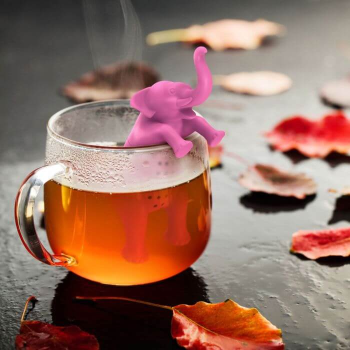 A elephant shaped Fred-brand tea strainer in a glass teacup: Big Brew